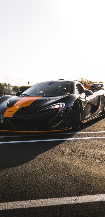 Image black and orange sports car on road during daytime