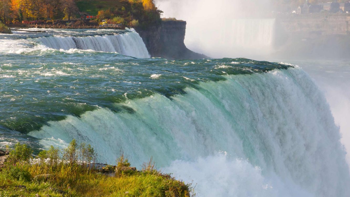 waterfalls near green grass field during daytime