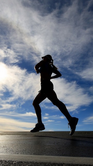 Image silhouette of woman jumping on beach during daytime