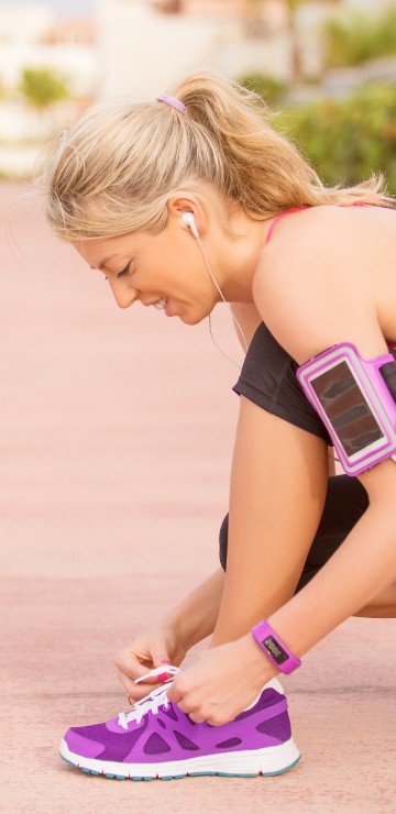 Image woman in pink tank top and purple nike athletic shoes sitting on brown wooden floor during