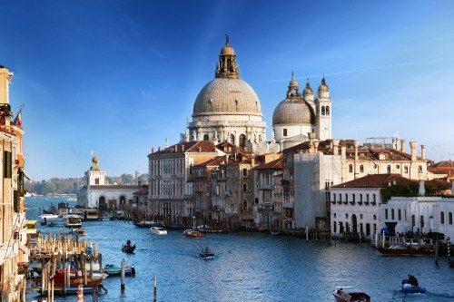 Image white and brown concrete building near body of water during daytime