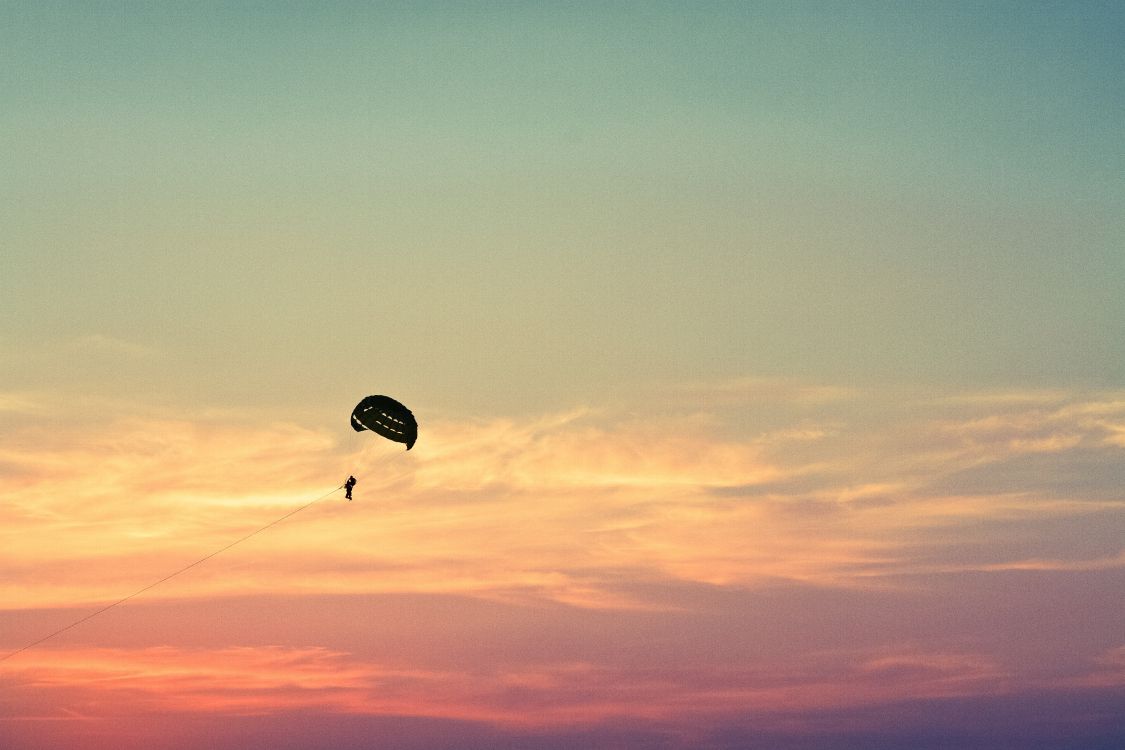 Persona en Paracaídas Bajo un Cielo Azul Durante el Día.. Wallpaper in 5184x3456 Resolution