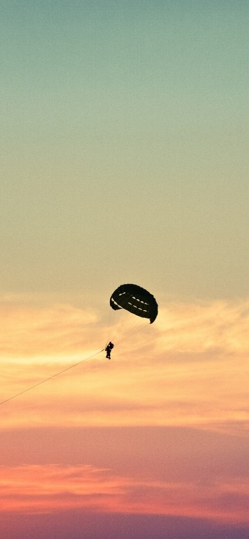 Image person in parachute under blue sky during daytime