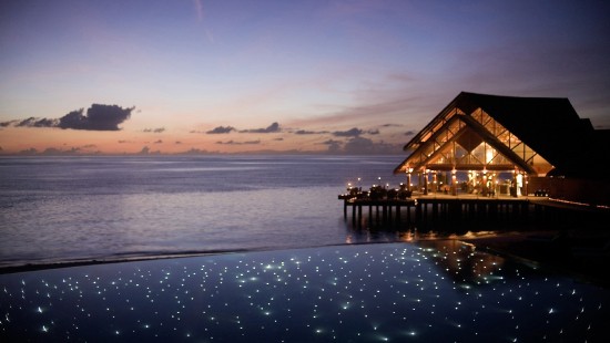 Image brown wooden house on body of water during sunset