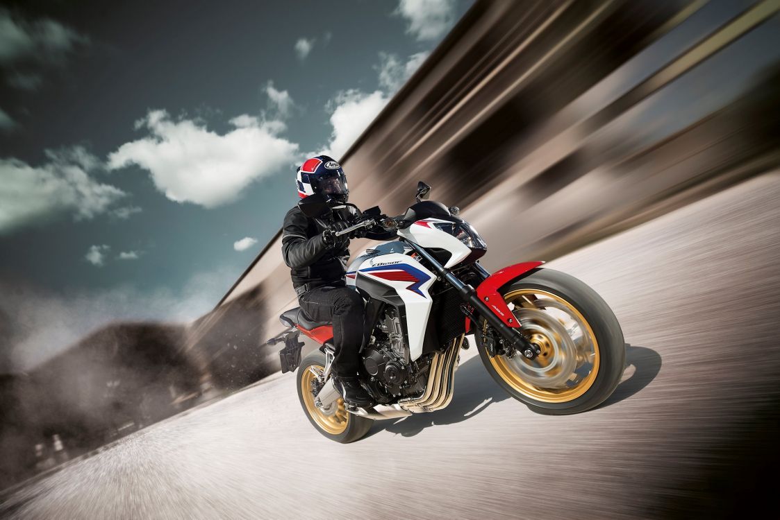 man in black and white motorcycle suit riding orange and black sports bike