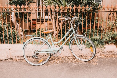 Image white city bike beside fence