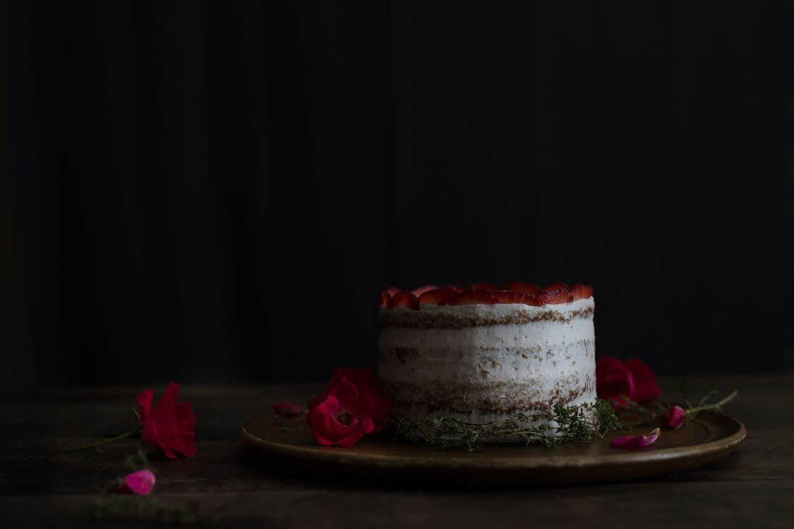 white and red cake on brown wooden table