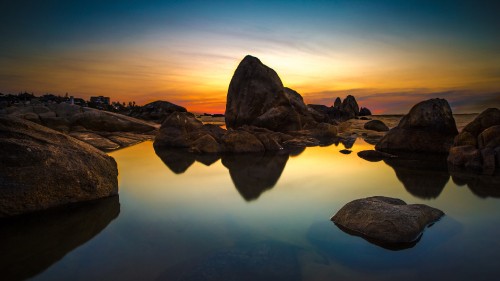 Image brown rock formation on body of water during daytime