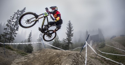 Image man in black jacket riding on white and black mountain bike