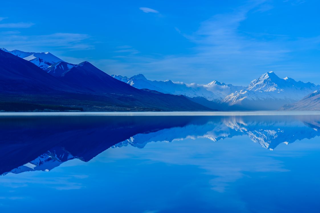 Cuerpo de Agua Cerca de la Montaña Bajo un Cielo Azul Durante el Día. Wallpaper in 6016x4016 Resolution