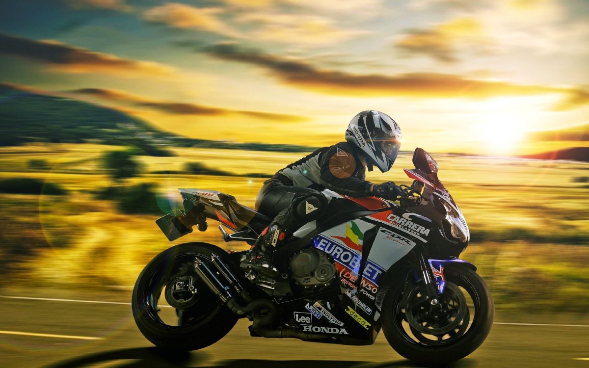 man in black and white motorcycle suit riding on black and yellow sports bike