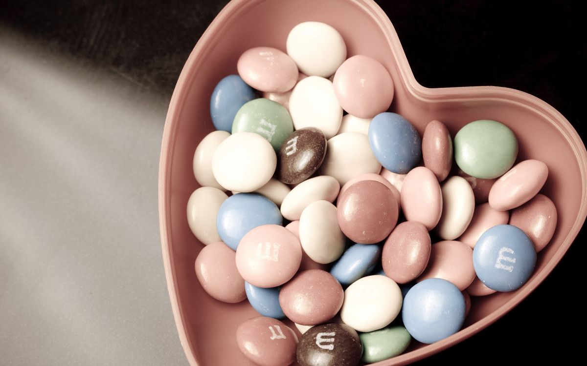 Blaurote Und Weiße Herzförmige Bonbons Auf Orangefarbenem Plastikbehälter. Wallpaper in 1920x1200 Resolution