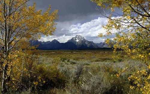 Image green grass field near mountain under white clouds during daytime