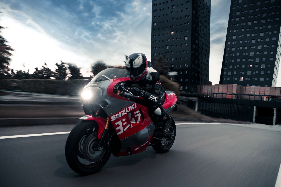 man in black and red motorcycle helmet riding red and black sports bike