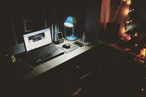 Image black and silver laptop computer on brown wooden desk