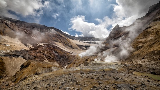Image brown and gray mountains under white clouds and blue sky during daytime