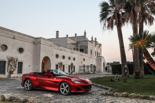 Image red ferrari 458 italia parked near brown concrete building during daytime