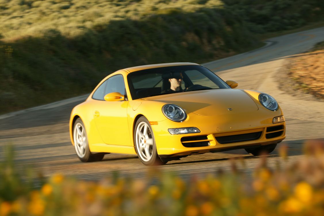 Gelber Porsche 911 Tagsüber Unterwegs. Wallpaper in 4064x2704 Resolution