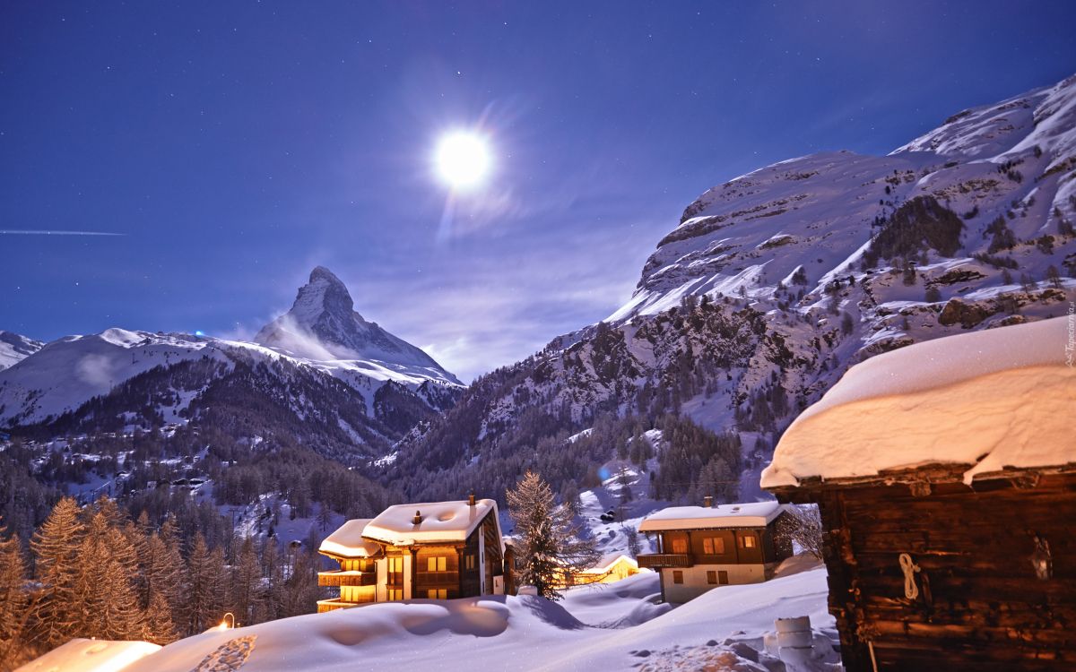 brown house on snow covered ground near snow covered mountain during daytime