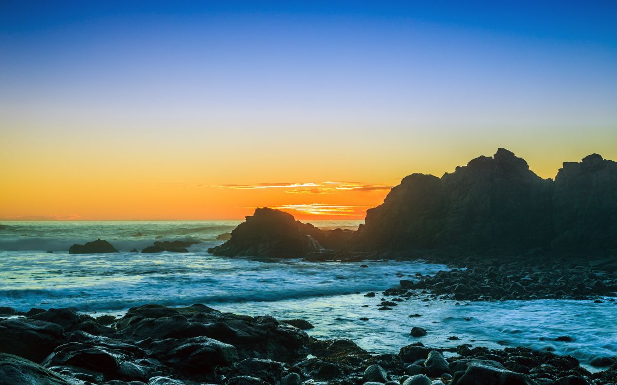 Ocean Waves Crashing on Rocks During Sunset. Wallpaper in 3840x2400 Resolution