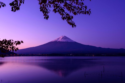 Image silhouette of person standing on rock near body of water during night time