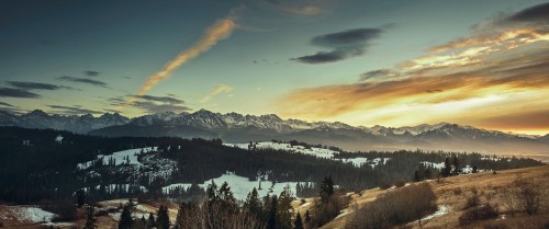 Image green trees and snow covered mountains under blue sky and white clouds during daytime