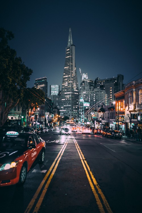 Image cars on road near high rise buildings during night time