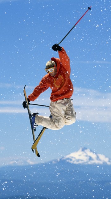 Image man in red jacket and white pants riding ski blades on snow covered ground during daytime