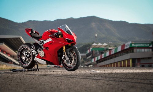 Image man in red sports bike racing on track field during daytime