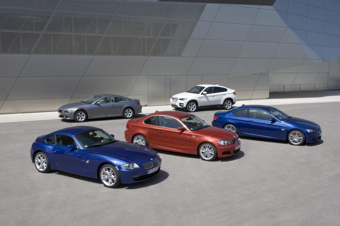 Blaues Bmw Coupe Neben Weißer Limousine Geparkt. Wallpaper in 1920x1280 Resolution