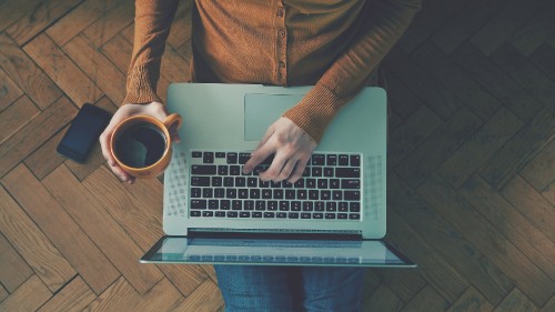 Image person in brown long sleeve shirt using macbook pro