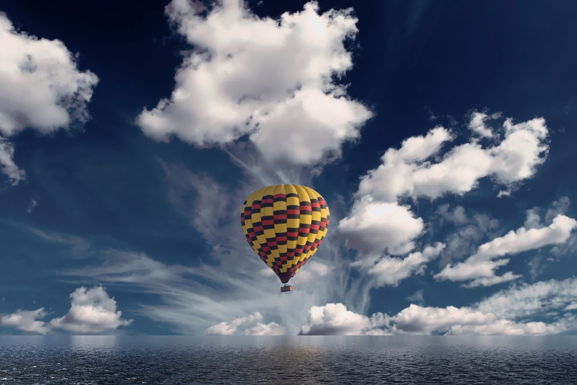 yellow and green hot air balloon in mid air under blue and white cloudy sky during