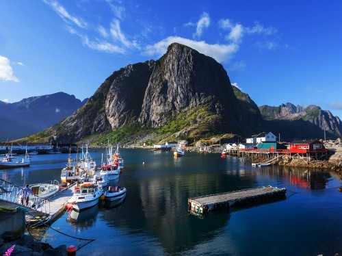 Image white and blue boat on water near mountain during daytime