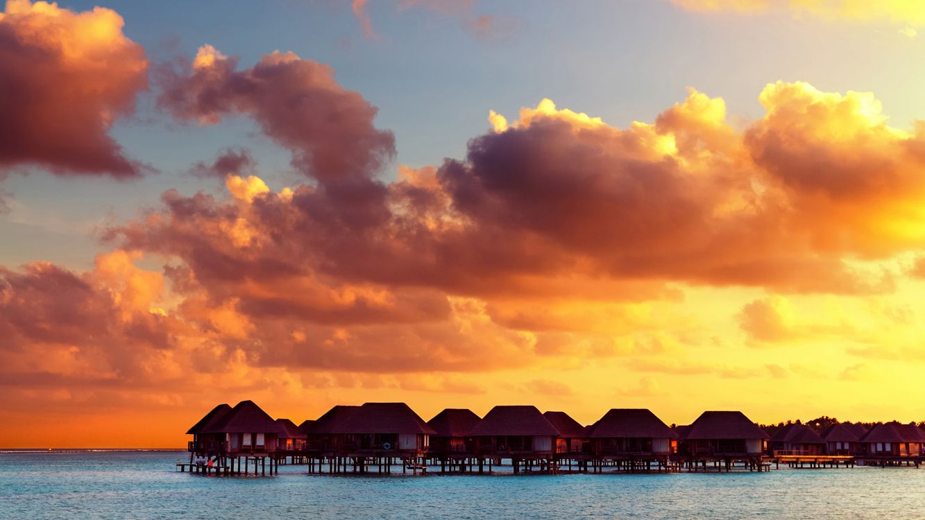 silhouette of house on beach during sunset