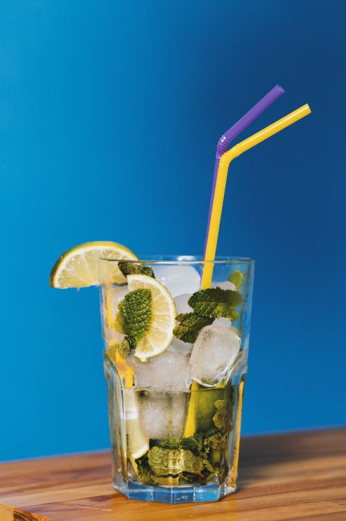 clear drinking glass with ice and straw