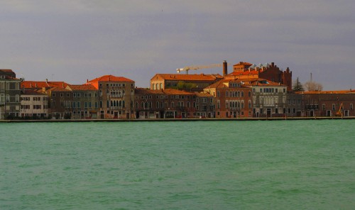 Image brown and white concrete building beside body of water during daytime