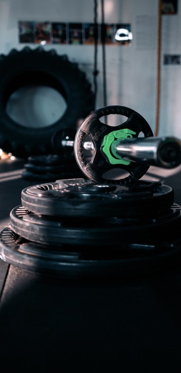 Image black and green dumbbell on black round plate