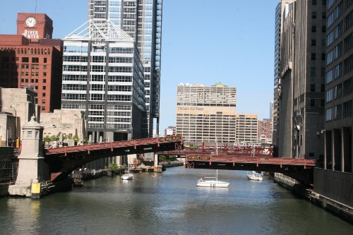 Image brown bridge over river near high rise buildings during daytime