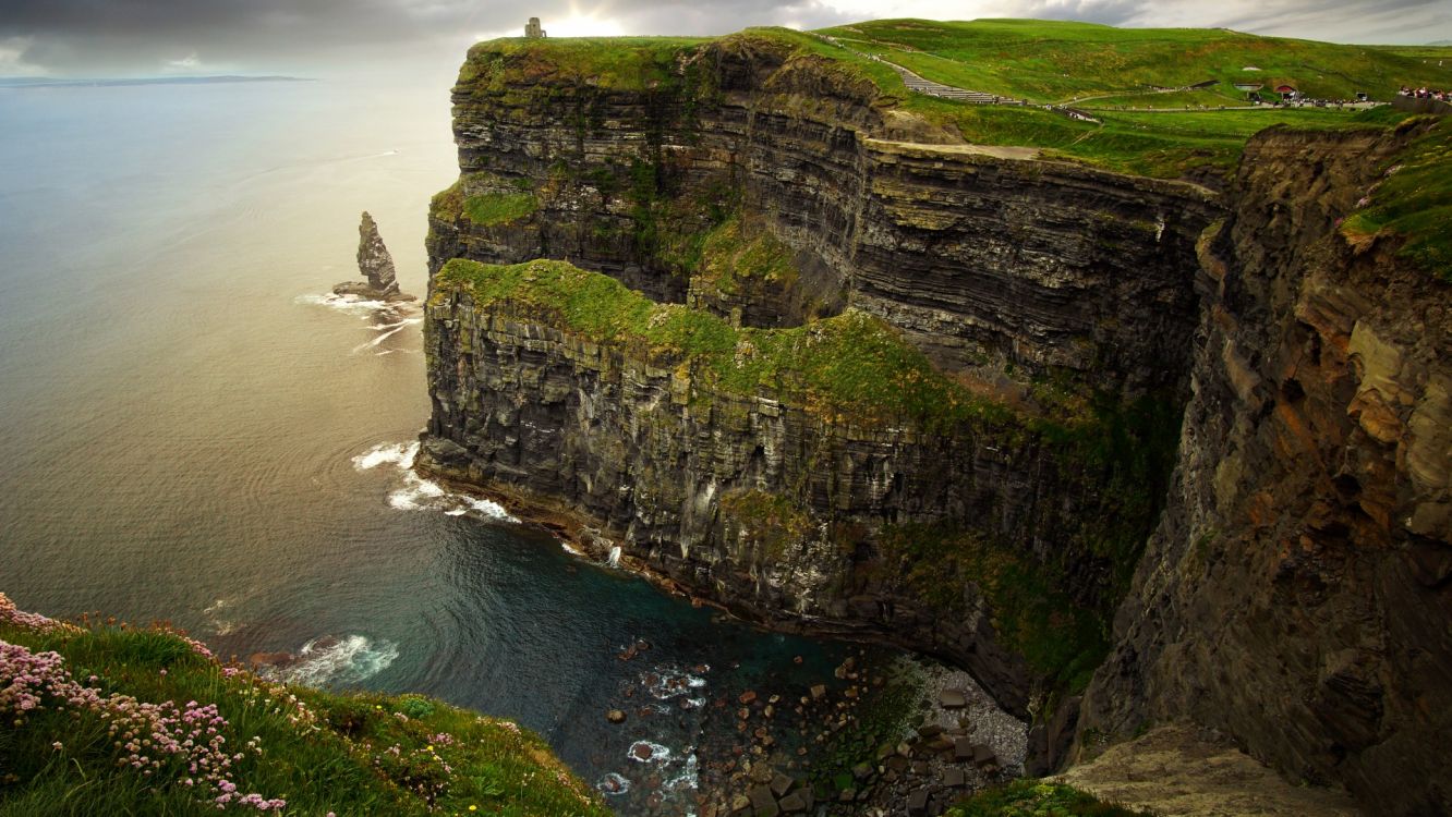 gray rock formation beside body of water during daytime