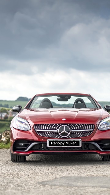 Image red and white bmw m 3 on green grass field under white clouds and blue sky