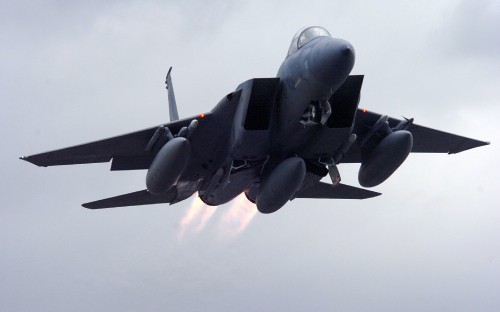 Image black jet plane in mid air during daytime