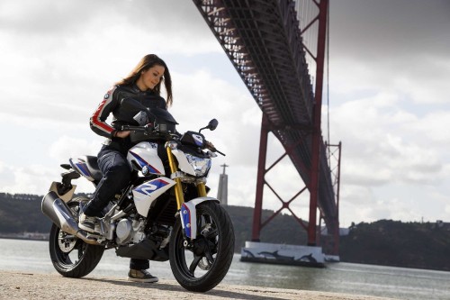 Image woman in black jacket riding yellow and black motorcycle