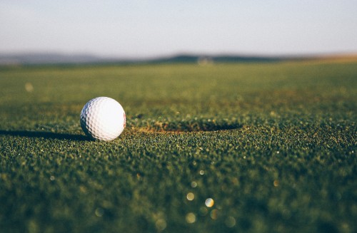 Image white golf ball on green grass field during daytime