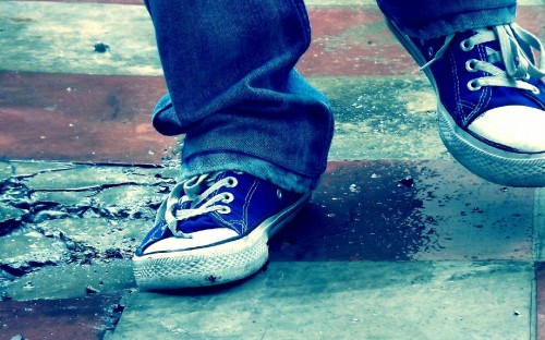 Image person in blue denim jeans and black and white nike sneakers