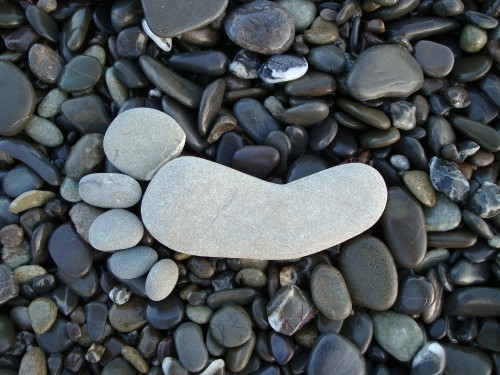 Image heart shaped gray stone on gray and black stones