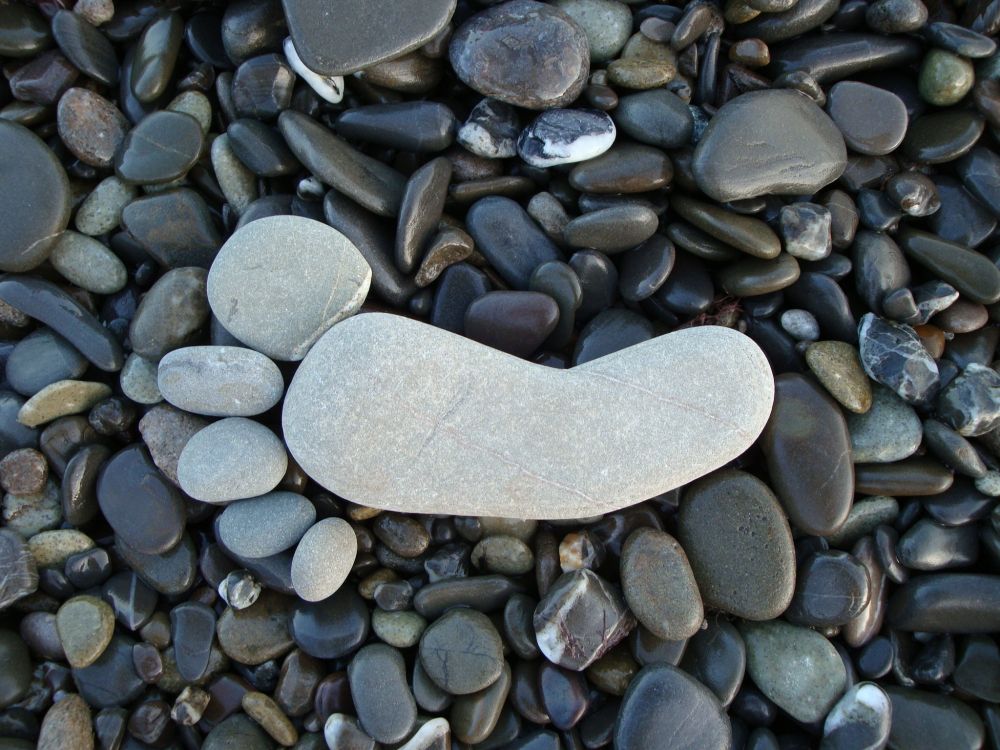 heart shaped gray stone on gray and black stones