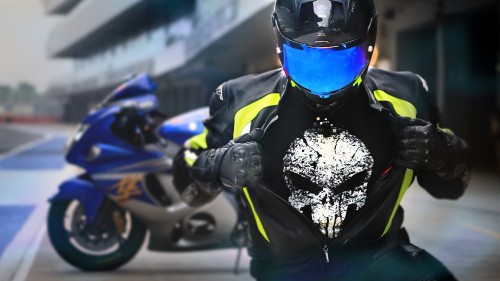 Image man in blue and black motorcycle suit riding on blue and black sports bike