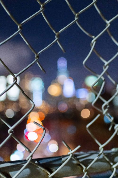 bokeh photography of gray metal fence