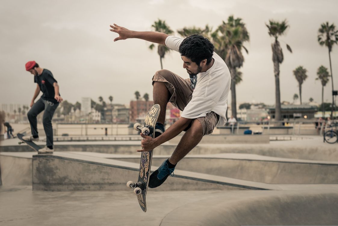 Hombre Con Camiseta Blanca y Pantalones Cortos Marrones Jugando Patineta Durante el Día. Wallpaper in 5355x3575 Resolution