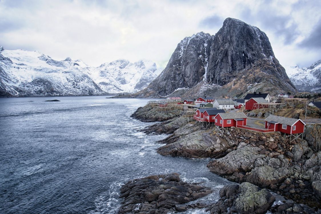 houses near body of water and mountain during daytime